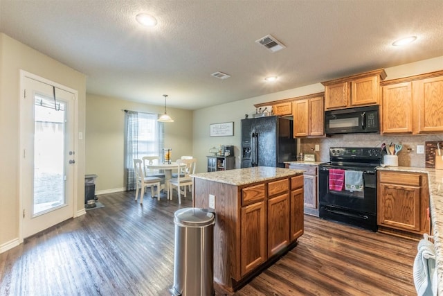 6806 Ambrose Cir, Temple, TX 76502 - kitchen featuring visible vents, dark wood-style flooring, decorative backsplash, black appliances, and hanging light fixtures