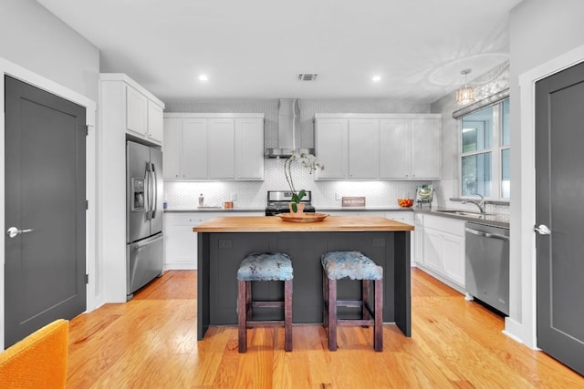 402 Irma Dr Unit B, Austin, TX 78752 - kitchen featuring butcher block countertops, a kitchen island, a breakfast bar, stainless steel appliances, and tasteful backsplash