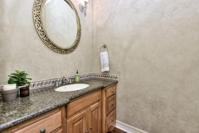 bathroom with baseboards, vanity, and wood finished floors