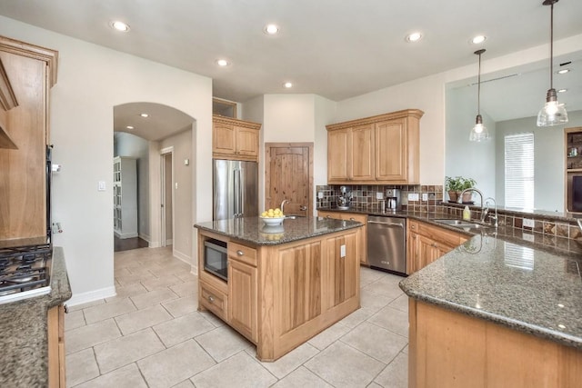kitchen featuring stainless steel appliances, dark stone countertops, light tile patterned floors, a sink, and decorative backsplash