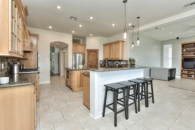 kitchen featuring tasteful backsplash, high end fridge, and visible vents