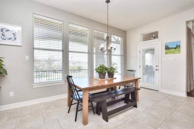 dining room featuring baseboards, a wealth of natural light, a notable chandelier, and light tile patterned floors