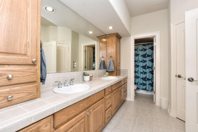 full bathroom featuring tile patterned flooring, a sink, double vanity, and recessed lighting