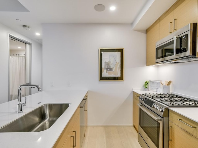 301 W Ave Unit 1301, Austin, TX 78701 - kitchen featuring stainless steel appliances, a sink, recessed lighting, light wood finished floors, and light countertops