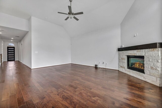 252 Sabino Dr, Buda, TX 78610 - unfurnished living room featuring a stone fireplace, wood finished floors, vaulted ceiling, a ceiling fan, and baseboards