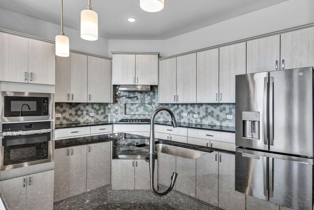 252 Sabino Dr, Buda, TX 78610 - kitchen featuring appliances with stainless steel finishes, a sink, tasteful backsplash, and pendant lighting
