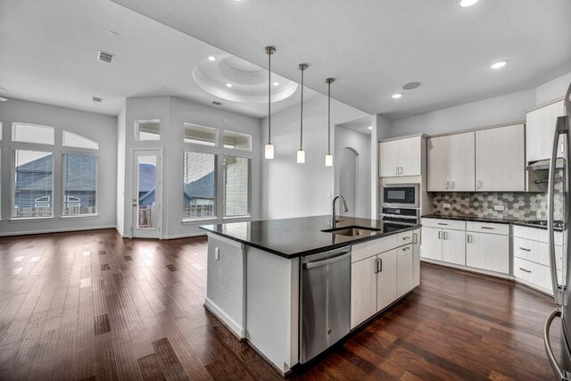 252 Sabino Dr, Buda, TX 78610 - kitchen with stainless steel appliances, a sink, dark countertops, dark wood-style floors, and recessed lighting
