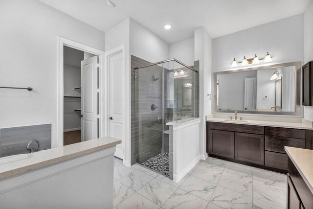 252 Sabino Dr, Buda, TX 78610 - bathroom featuring a stall shower, vanity, a walk in closet, marble look tile flooring, and recessed lighting