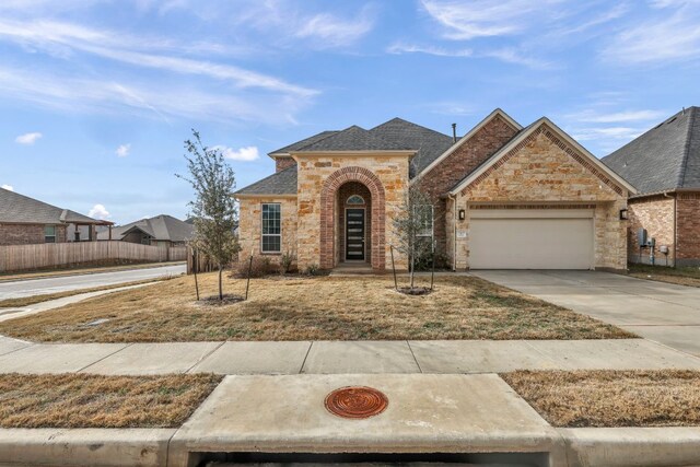 252 Sabino Dr, Buda, TX 78610 - view of front of home featuring an attached garage, driveway, stone siding, and roof with shingles