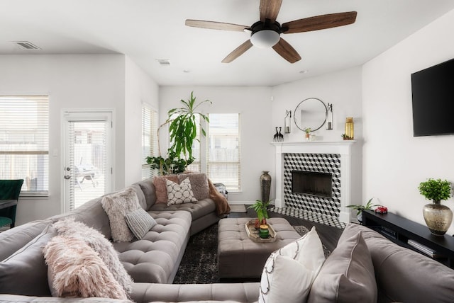 living area with visible vents, a healthy amount of sunlight, and a ceiling fan