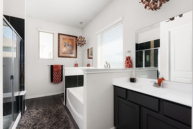 full bathroom featuring a bath, wood finished floors, a stall shower, and a wealth of natural light
