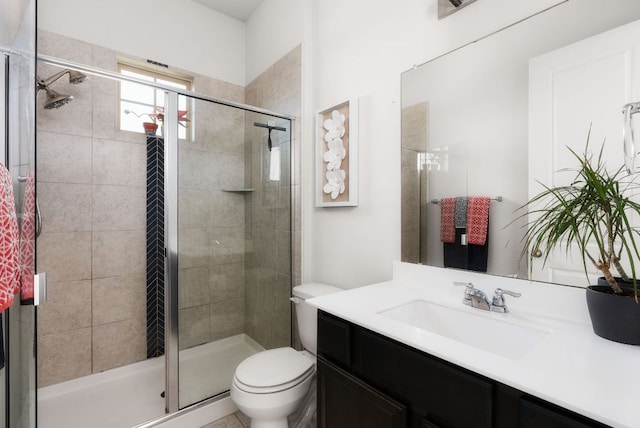 bathroom featuring toilet, a stall shower, and vanity