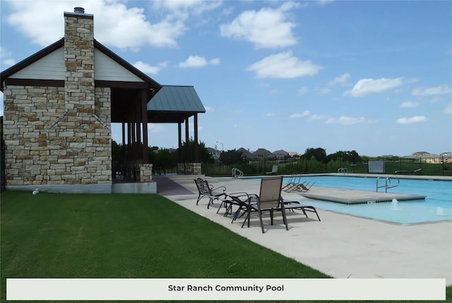 community pool featuring a yard, fence, and a patio area