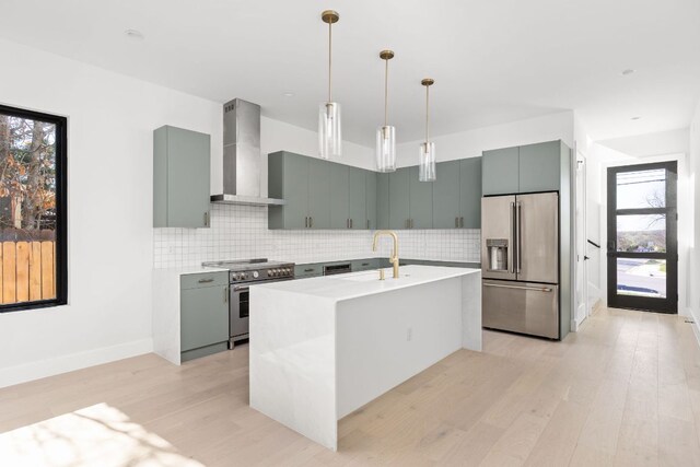 802 Philco Dr Unit 1, Austin, TX 78745 - kitchen with stainless steel appliances, wall chimney exhaust hood, light wood-type flooring, backsplash, and decorative light fixtures