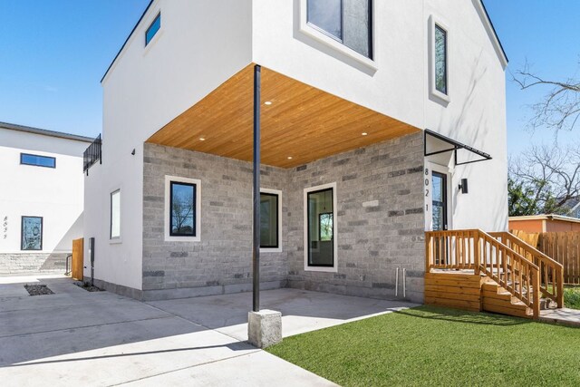 802 Philco Dr Unit 1, Austin, TX 78745 - back of house with stone siding, a yard, a patio area, and stucco siding