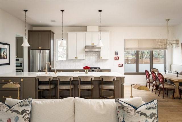 4408 Jinx Ave Unit 1, Austin, TX 78745 - kitchen featuring freestanding refrigerator, light wood-style floors, light countertops, backsplash, and a breakfast bar area