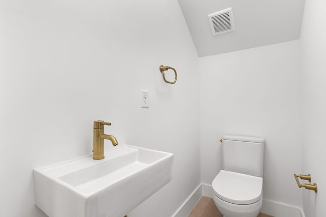 802 Philco Dr Unit 2, Austin, TX 78745 - bathroom featuring a sink, lofted ceiling, toilet, baseboards, and wood finished floors