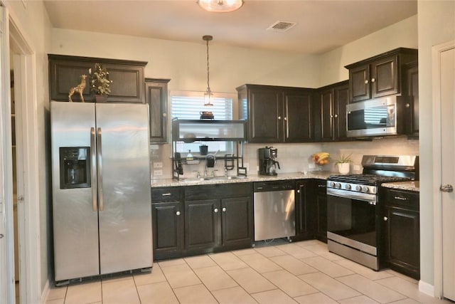 1400 Bess Cv, Leander, TX 78641 - kitchen with appliances with stainless steel finishes, a sink, tasteful backsplash, light stone countertops, and decorative light fixtures