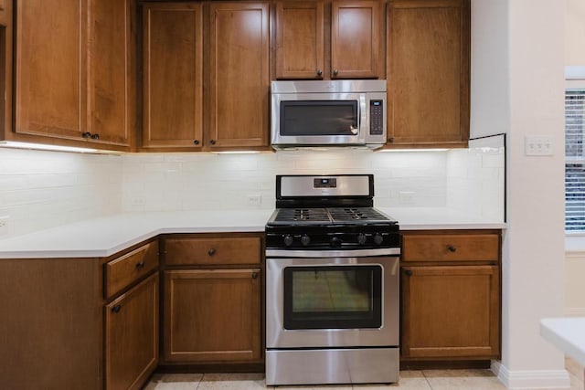 422 Village Commons Blvd, Georgetown, TX 78633 - kitchen with appliances with stainless steel finishes, light countertops, tasteful backsplash, baseboards, and brown cabinets