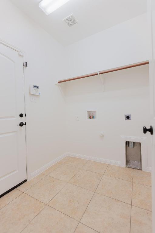 422 Village Commons Blvd, Georgetown, TX 78633 - laundry room with washer hookup, electric dryer hookup, hookup for a gas dryer, light tile patterned flooring, and baseboards