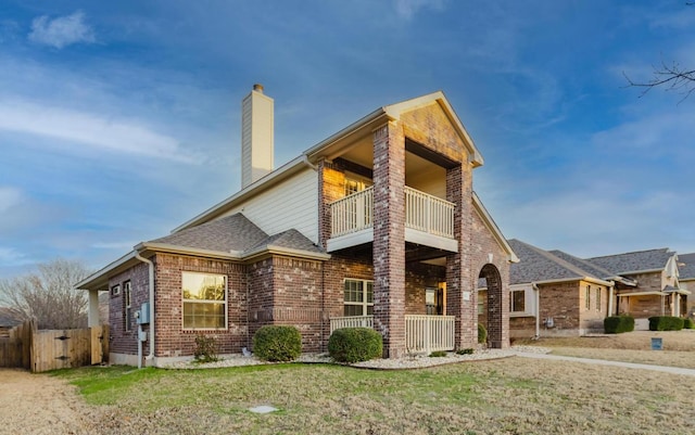 422 Village Commons Blvd, Georgetown, TX 78633 - view of front facade featuring a balcony, a chimney, brick siding, roof with shingles, and covered porch
