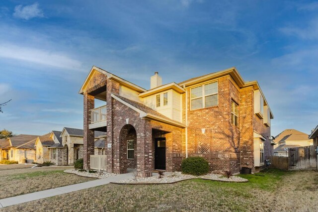 422 Village Commons Blvd, Georgetown, TX 78633 - view of front of property featuring a balcony, brick siding, and a chimney