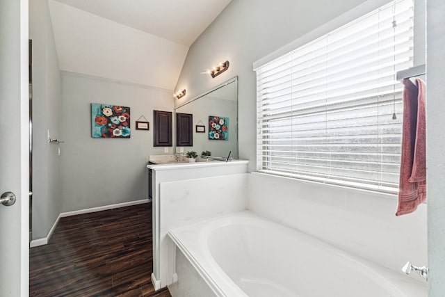 2502 Grey Kirby Dr, League City, TX 77573 - bathroom with a bath, vanity, wood finished floors, lofted ceiling, and baseboards