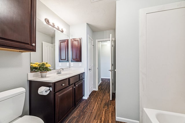 2502 Grey Kirby Dr, League City, TX 77573 - bathroom featuring wood finished floors, vanity, baseboards, toilet, and a tub