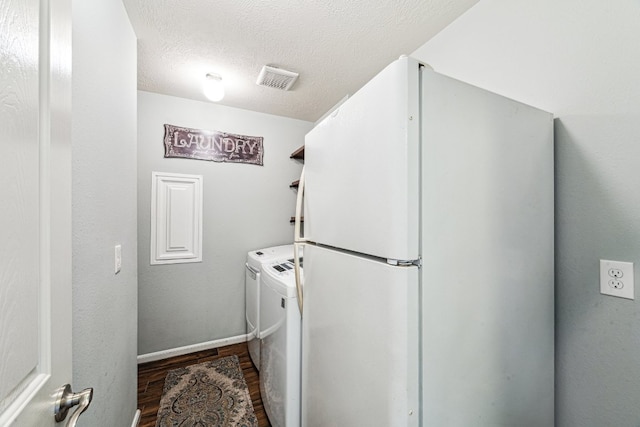 2502 Grey Kirby Dr, League City, TX 77573 - washroom with dark wood finished floors, washer and clothes dryer, a textured ceiling, and baseboards