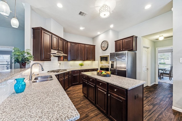 2502 Grey Kirby Dr, League City, TX 77573 - kitchen with appliances with stainless steel finishes, a sink, under cabinet range hood, dark brown cabinets, and recessed lighting