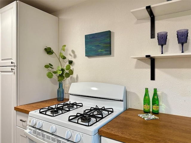 kitchen with white cabinetry and white gas stove