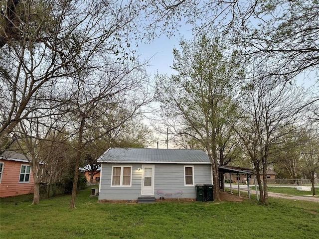 view of outdoor structure with fence, entry steps, and a carport