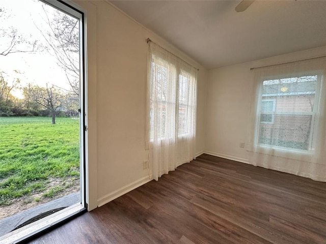 spare room featuring dark wood-style floors and baseboards