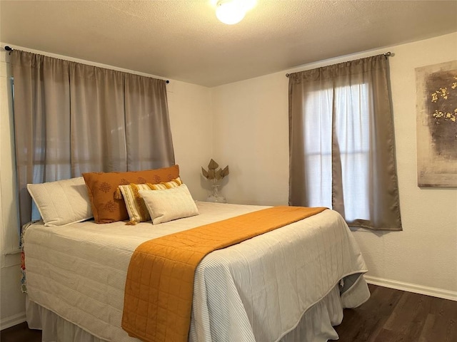 bedroom with wood finished floors and baseboards