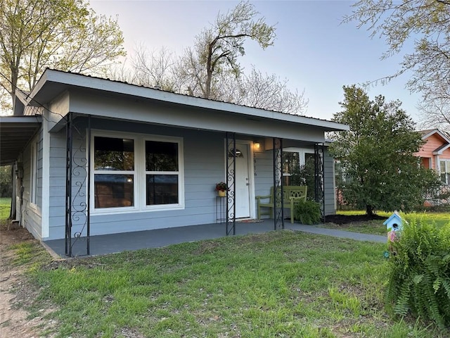 view of front of house featuring covered porch and a front lawn