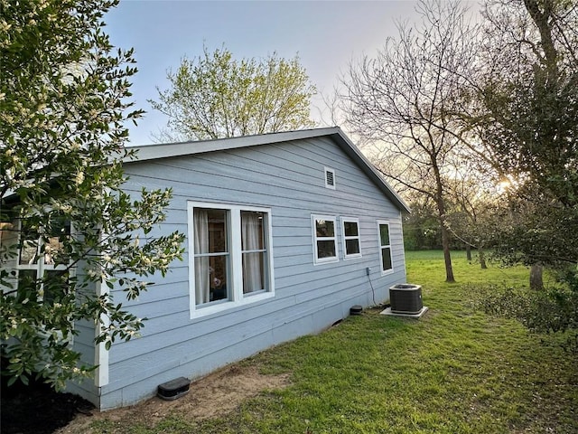 view of home's exterior featuring cooling unit and a lawn