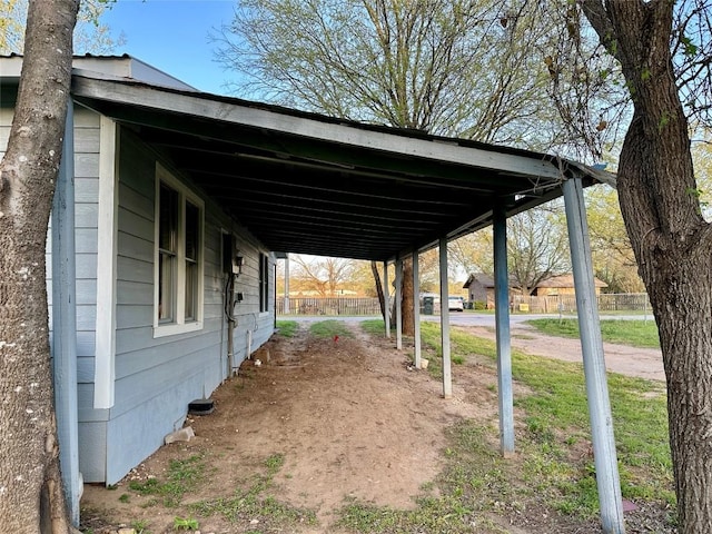 exterior space with a carport and fence