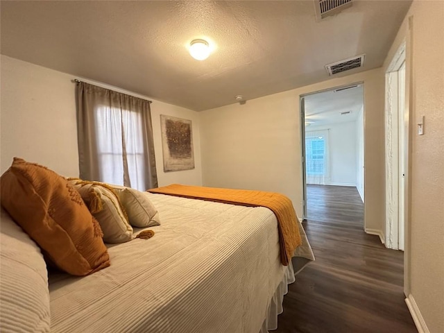 bedroom featuring visible vents, wood finished floors, and baseboards
