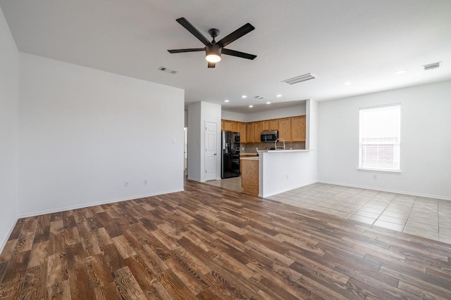 101 Verde Ranch Loop, Leander, TX 78641 - unfurnished living room with wood finished floors, ceiling fan, recessed lighting, baseboards, and a sink