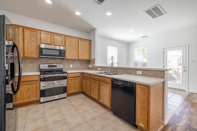 101 Verde Ranch Loop, Leander, TX 78641 - kitchen with appliances with stainless steel finishes, a sink, a peninsula, decorative backsplash, and recessed lighting