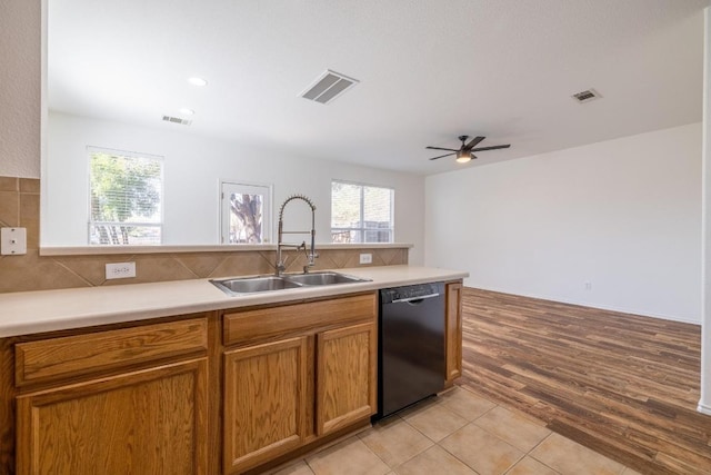 101 Verde Ranch Loop, Leander, TX 78641 - kitchen featuring dishwasher, a sink, ceiling fan, brown cabinets, and tasteful backsplash