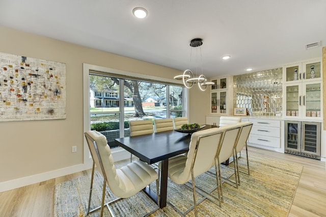 8702 Silverhill Ln, Austin, TX 78759 - dining room with beverage cooler, bar area, light wood finished floors, a chandelier, and recessed lighting