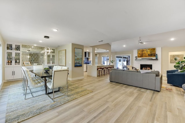 8702 Silverhill Ln, Austin, TX 78759 - dining space with light wood-style floors, a fireplace, baseboards, recessed lighting, and a chandelier