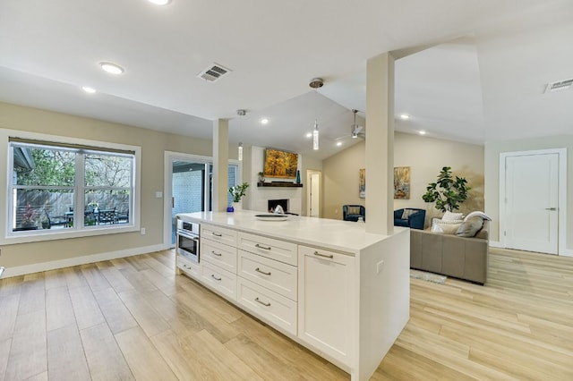 8702 Silverhill Ln, Austin, TX 78759 - kitchen with open floor plan, white cabinets, light wood-type flooring, vaulted ceiling, and light countertops