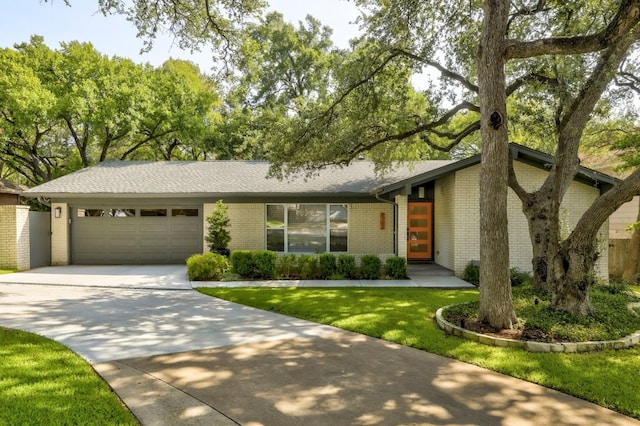 8702 Silverhill Ln, Austin, TX 78759 - view of front of home with an attached garage, driveway, brick siding, a front yard, and roof with shingles