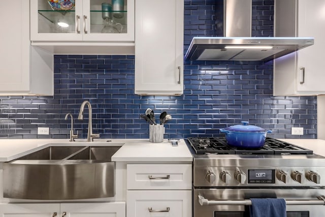 8702 Silverhill Ln, Austin, TX 78759 - kitchen with stainless steel gas range, wall chimney range hood, backsplash, and light countertops