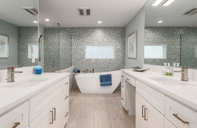 8702 Silverhill Ln, Austin, TX 78759 - full bath with a stall shower, two vanities, tile walls, tile patterned floors, and a freestanding tub