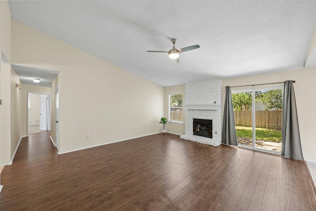 11921 Tanglebriar Trl, Austin, TX 78750 - unfurnished living room featuring ceiling fan, wood finished floors, a brick fireplace, lofted ceiling, and baseboards
