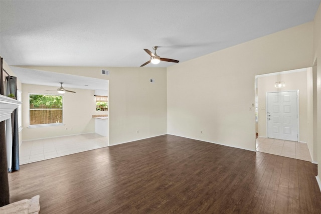 11921 Tanglebriar Trl, Austin, TX 78750 - unfurnished living room with a ceiling fan, wood finished floors, a fireplace, and vaulted ceiling