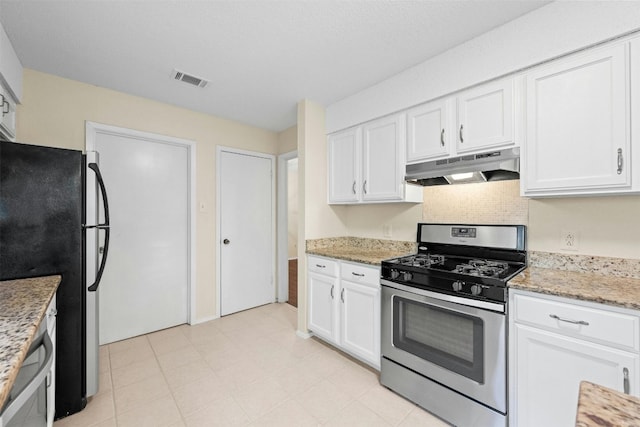 11921 Tanglebriar Trl, Austin, TX 78750 - kitchen featuring stainless steel range with gas stovetop, under cabinet range hood, freestanding refrigerator, and white cabinets